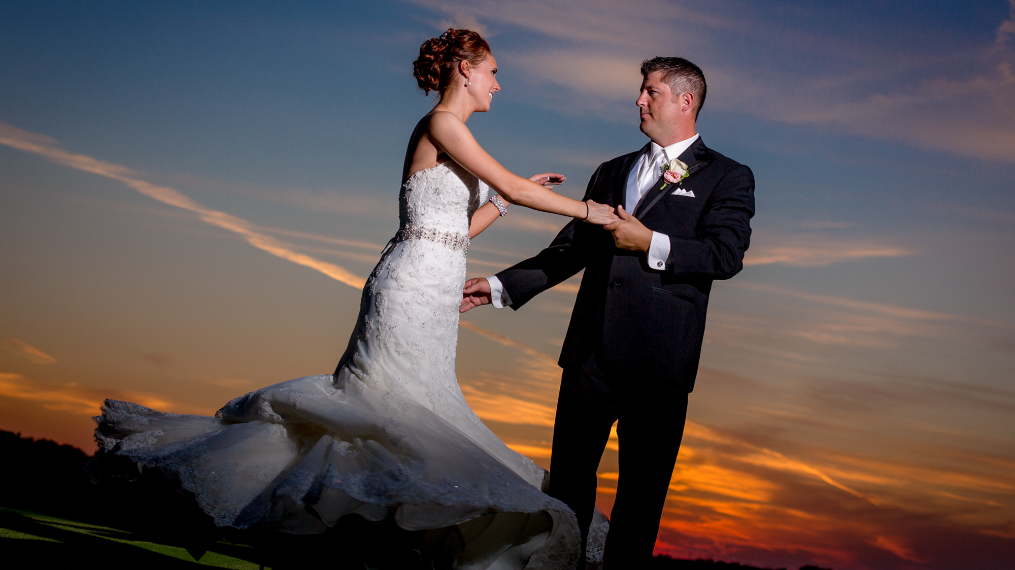 Dallas wedding video still frame of a groom spinning his bride in the sunset.